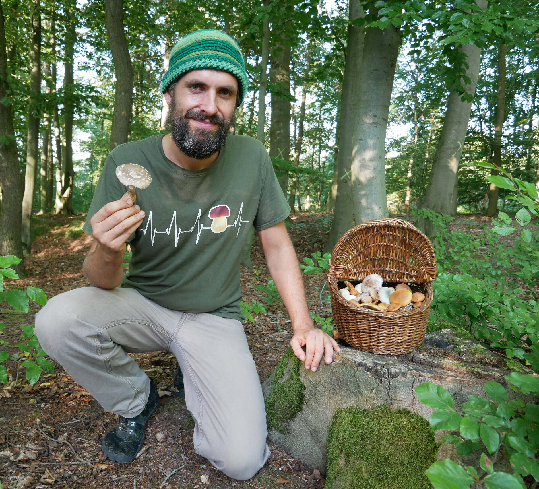 Pilzberater Raphael Gorschlüter mit einem Korb voller Speisepilze
